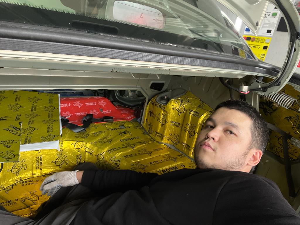 Руслан укладывает шумоизоляцию в автомобиле